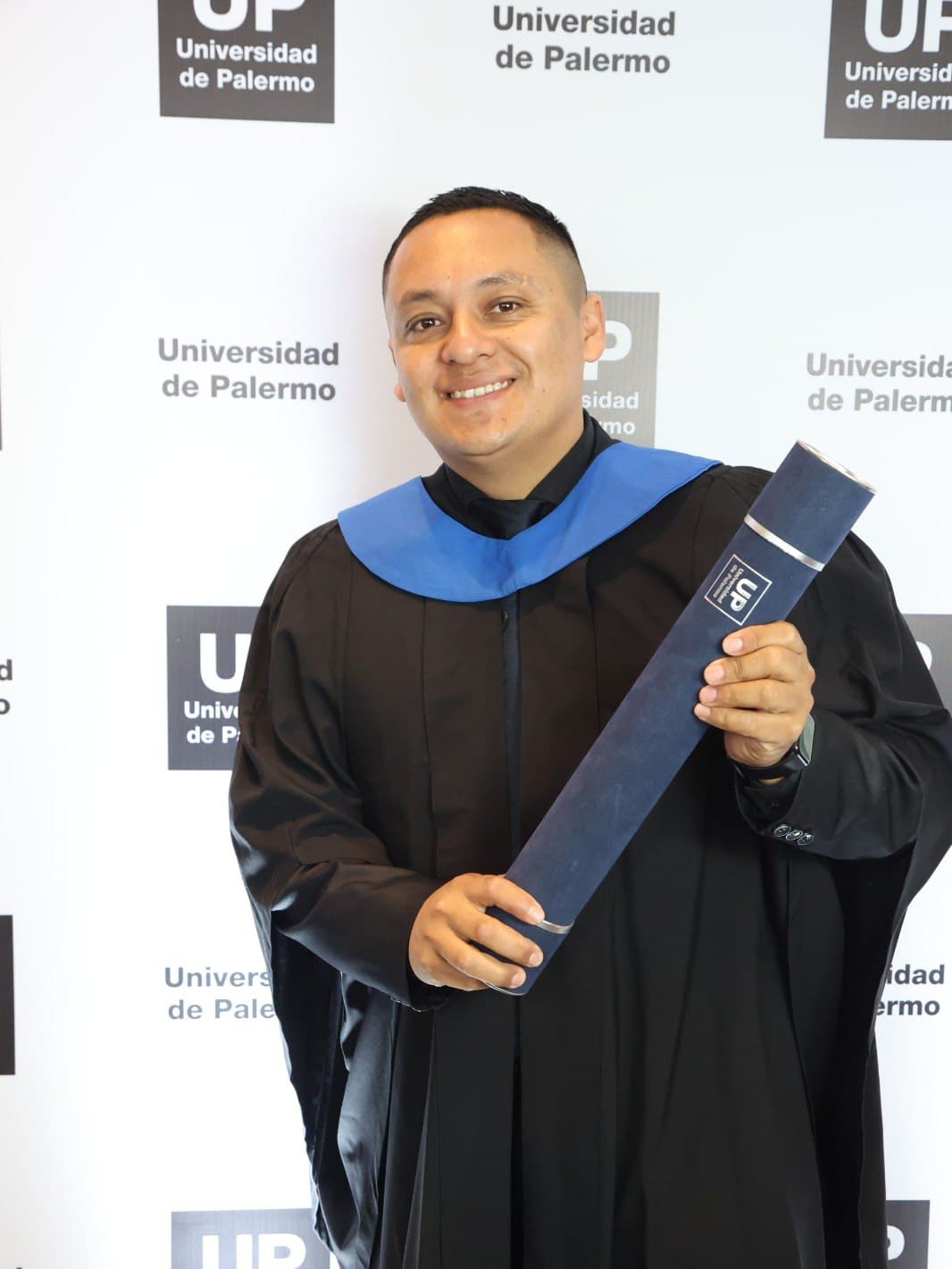 Miguel Moreira con toga y el diploma en la mano, en su graduación de la Universidad de Palermo